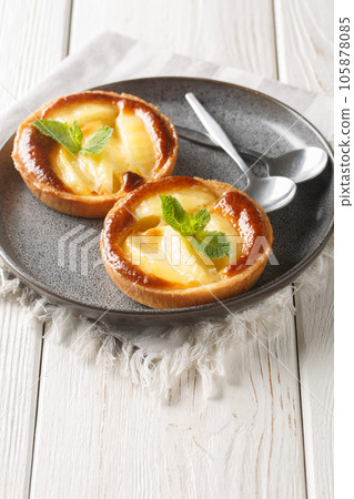 Homemade fresh mini apple pie tarts with mint close-up in a plate. Vertical 105878085