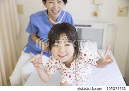 A girl and a nurse cheerfully posing in a hospital room, soon to be discharged from the hospital A girl and a nurse cheerfully posing in a hospital room, soon to be discharged from the hospital 105878562