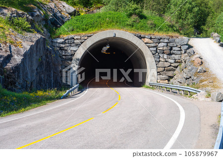 Road tunnel through the mountains. Norway tunnel through a high mountain in the north of the country Road tunnel through the mountains. Norway tunnel through a high mountain in the north of the country 105879967