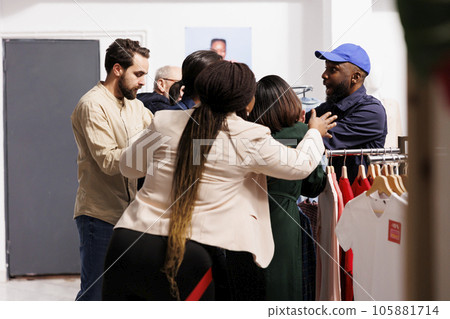 Stressed African American guy security officer standing at clothing store entrance managing crowd of shoppers breaking into store on Black Friday. Mad Angry people customers waiting in line for sales 105881714