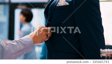 Asian worker arranging elegant suit, checking racks and hangers full with fashionable clothes and stylish accessories in modern boutique. Employee working at shopping centre visual. Fashion concept 105881741