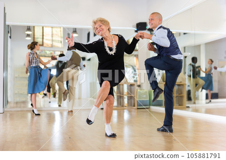 Mature woman learning to dance lindy hop with younger man 105881791