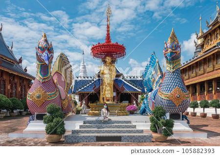 Asian female tourist come to worship at Wat Ban Den or Wat Den Salee Sri Muang Gan the Lanna style temple and colorful statue sculpture at Chiang Mai 105882393