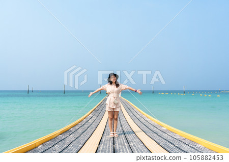 Young asian woman standing on pontoon walkway in tropical sea Young asian woman standing on pontoon walkway in tropical sea 105882453