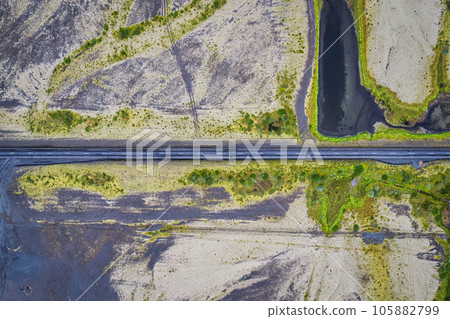 Asphalt road cut through mossy remote wilderness in rural scene 105882799