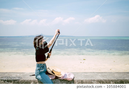 Travel to Okinawa A woman strolling along the beach 105884001