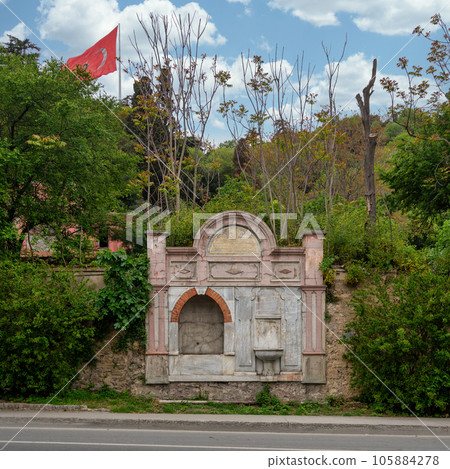 Kadin Efendi Cesmesi, fountain house in Besiktas, Istanbul, Turkey, made of carved marble and stone, surrounded by trees 105884278