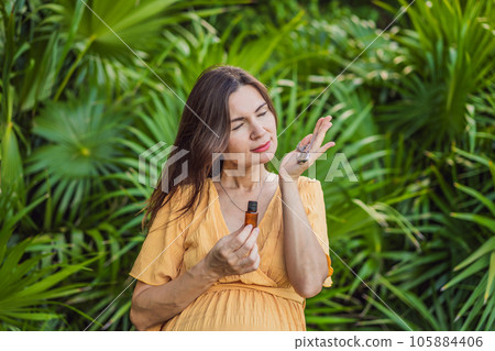 pregnant woman after 40 demonstrating the use of an aroma pendant, combining style and aromatherapy during her pregnancy journey pregnant woman after 40 demonstrating the use of an aroma pendant, combining style and aromatherapy during her pregnancy journey 105884406