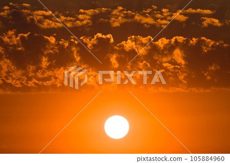 Cloudy sky and bright sun rise over the horizon. 105884960