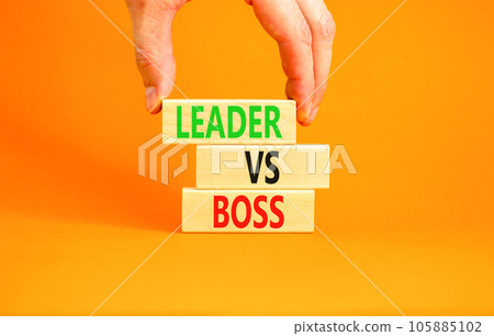Boss vs leader symbol. Concept words Boss vs versus leader on wooden block. Beautiful orange table orange background. Businessman hand. Business motivational boss vs leader concept. Copy space. 105885102