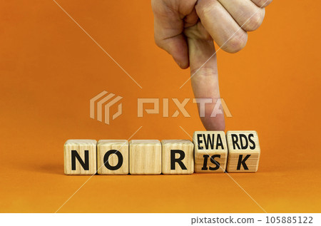 No risk and rewards symbol. Businessman turns wooden cubes and changes words 'no risk' to 'no rewards'. Beautiful orange background. No risk and rewards, business concept. Copy space. 105885122