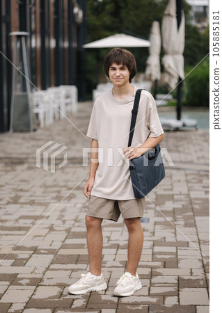 Young teenage boy student with laptop bag go home after college Young teenage boy student with laptop bag go home after college 105885181