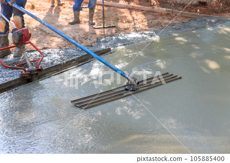 In addition to leveling concrete for driveways, workers use trowel level In addition to leveling concrete for driveways, workers use trowel level 105885400