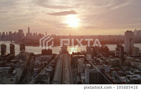 As sun sets Williamsburg Bridge in New York City creates picturesque backdrop for panoramic view of Manhattan across East River. As sun sets Williamsburg Bridge in New York City creates picturesque backdrop for panoramic view of Manhattan across East River. 105885418