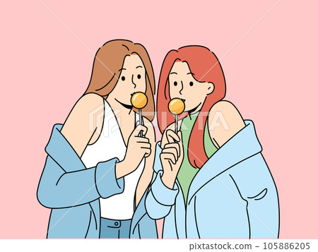 Two women with chupa chups in hands dressed in fashionable seductive clothes eat lollipops 105886205