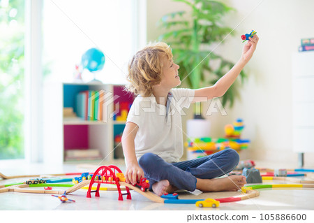 Child with toy train. Kids wooden railway. 105886600