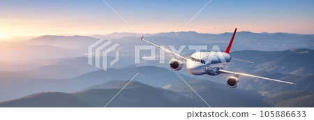 Plane is flying in colorful sky at sunset. Passenger airplane Plane is flying in colorful sky at sunset. Passenger airplane 105886633