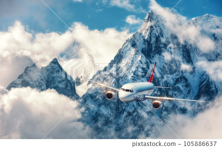 Airplane is flying over clouds against mountains 105886637