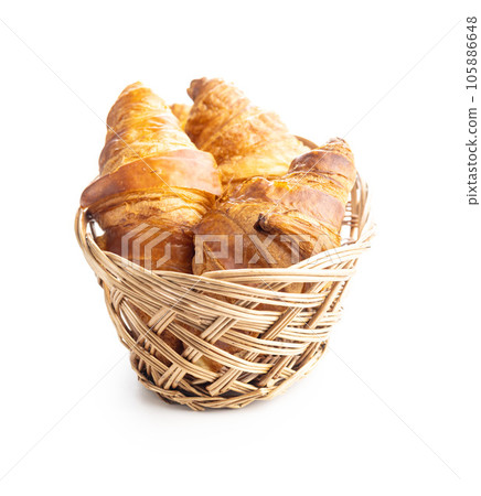 Fresh butter croissant in basket isolated on white background. 105886648