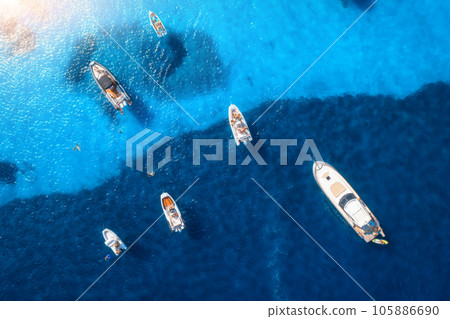 Aerial view of luxury yachts and boats on blue sea at sunset 105886690