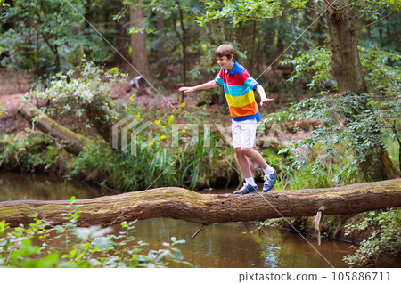 Child hiking in mountains. Kids at river shore. 105886711