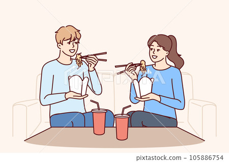 Couple eat boxed wok noodles sitting on couch using chopsticks delivered from chinese restaurant Couple eat boxed wok noodles sitting on couch using chopsticks delivered from chinese restaurant 105886754