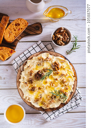 Trendy butter board with honey and walnuts for breakfast on the table top and vertical view 105887077