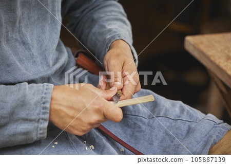 Guy carving wood at viking festival in Denmark. Close-up 105887139