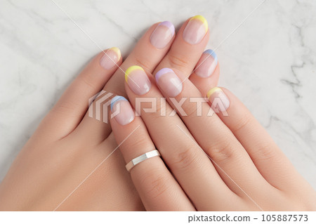 Beautiful womans hands with spring summer nail design on marble gray background 105887573