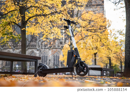 One modern green electric scooter sharing parked at Magdeburg city dom square alley street. Self-service street transport rental service. Rent urban mobility vehicle. Zero emission green eco energy One modern green electric scooter sharing parked at Magdeburg city dom square alley street. Self-service street transport rental service. Rent urban mobility vehicle. Zero emission green eco energy 105888154