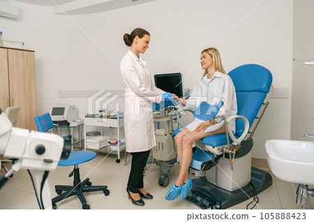 Woman is talking and shaking hands with a gynecologist in woman consultation during appointment 105888423