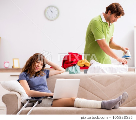 Husband helping leg injured wife in housework Husband helping leg injured wife in housework 105888555