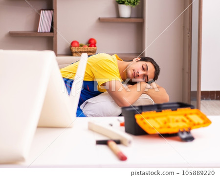 Young male contractor repairing chair at home 105889220