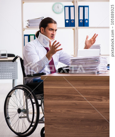 Neck injured young male employee in wheel-chair at workplace Neck injured young male employee in wheel-chair at workplace 105889325