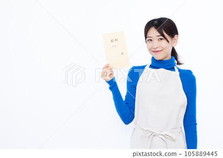 A smiling 30s housewife holding a pay bag in front of a white background A smiling 30s housewife holding a pay bag in front of a white background 105889445