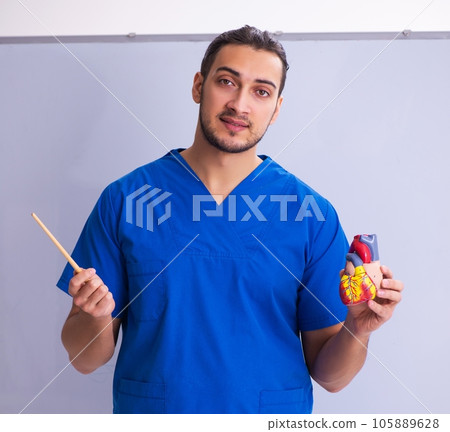 Young male doctor teacher cardiologist in front of whiteboard Young male doctor teacher cardiologist in front of whiteboard 105889628