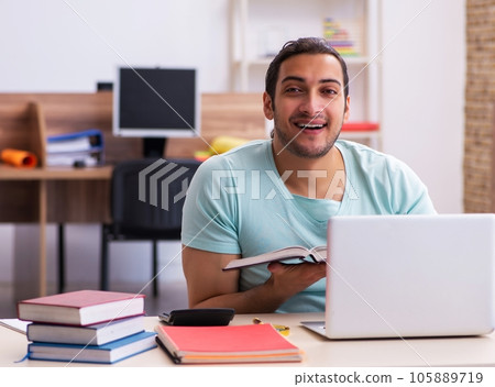 Young male student preparing for exams at home in tele-education 105889719