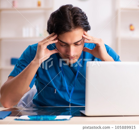 Young handsome doctor working in the clinic Young handsome doctor working in the clinic 105889915