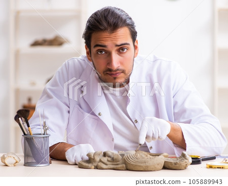 Young male archaeologist studying ancient african stonemask Young male archaeologist studying ancient african stonemask 105889943