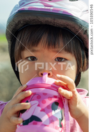 Child drinking a drink while cycling Child drinking a drink while cycling 105890546