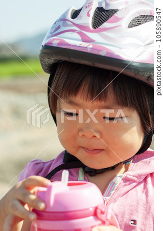 Child drinking a drink while cycling Child drinking a drink while cycling 105890547
