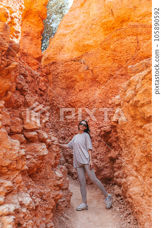 Hiker woman in Bryce Canyon resting enjoying view in beautiful nature landscape with hoodoos, pinnacles and spires rock formations. Bryce Canyon National Park landscape in Utah, United States.  105890592