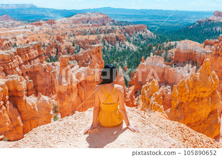 Hiker woman in Bryce Canyon resting enjoying view in beautiful nature landscape with hoodoos, pinnacles and spires rock formations in Utah 105890652