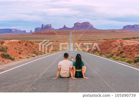 Happy couple on the famous road to Monument Valley in Utah. Amazing view of the Monument valley. Happy couple on the famous road to Monument Valley in Utah. Amazing view of the Monument valley. 105890739