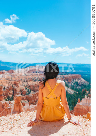 Hiker woman in Bryce Canyon resting enjoying view in beautiful nature landscape with hoodoos, pinnacles and spires rock formations in Utah 105890791