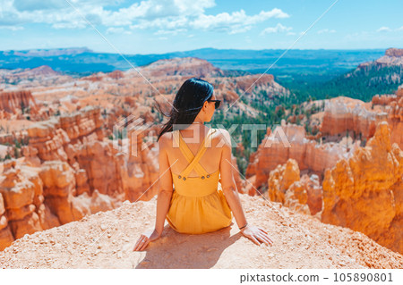 Hiker woman in Bryce Canyon resting enjoying view in beautiful nature landscape with hoodoos, pinnacles and spires rock formations in Utah 105890801