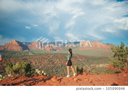 Young hiker woman on the edge of a cliff at Cathedral Rock in Sedona, Arizona. View from Scenic Cathedral Rock in Sedona with blue sky in Arizona 105890846