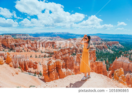 Hiker woman in Bryce Canyon resting enjoying view in beautiful nature landscape with hoodoos, pinnacles and spires rock formations in Utah 105890865
