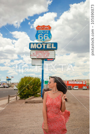 Beautiful woman in red dress on famous Highway under popular sign Route 66 Beautiful woman in red dress on famous Highway under popular sign Route 66 105890873