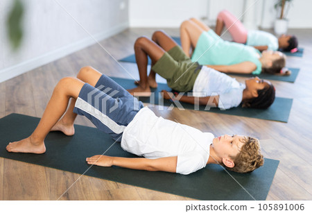 Kids yoga exercise - setu bandha sarvangasana. 105891006